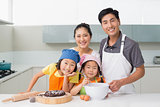 Family of four preparing cookies in kitchen