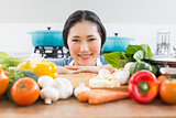 Smiling woman in front of vegetables in kitchen