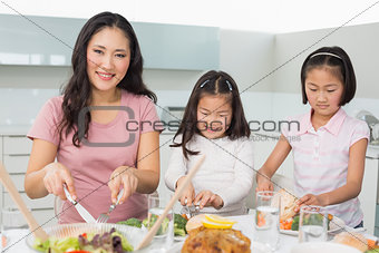 Woman with two little girls having food in kitchen