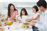 Family of four enjoying healthy meal in kitchen