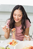 Happy young woman enjoying spaghetti lunch