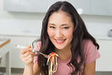 Portrait of a happy young woman enjoying spaghetti lunch