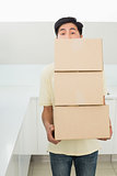 Young man carrying boxes in front of his face