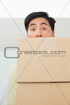 Close-up portrait of a young man carrying boxes