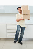 Smiling casual young man carrying boxes