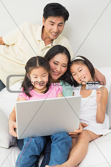 Happy family of four doing online shopping
