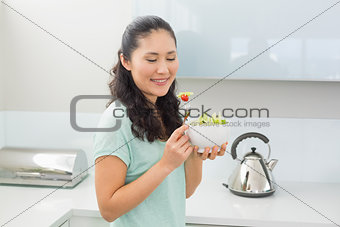 Smiling woman with a bowl of salad in kitchen