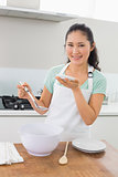 Portrait of a smiling woman preparing food in kitchen