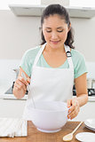 Smiling young woman preparing food in kitchen