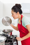 Side view of a young woman preparing food in kitchen