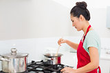 Side view of a woman preparing food in kitchen