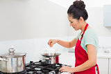 Side view of a woman preparing food in kitchen