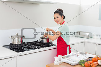 Rear view portrait of a woman preparing food in kitchen