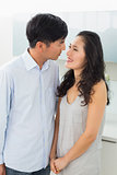 Side view of a romantic young couple in kitchen