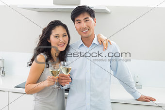 Loving couple with wine glasses in kitchen