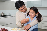 Cheerful father with daughter having cereals in kitchen
