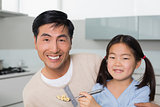 Father with young daughter having cereals in kitchen