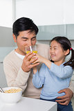 Father with daughter having breakfast in kitchen