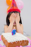 Girl covering her face at the birthday party