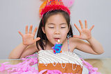 Cute little girl blowing her birthday cake