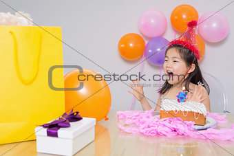 Cheerful surprised little girl at her birthday party