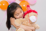 Cute girl hugging soft toy at a birthday party