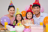 Family of four with cake and gifts at a birthday party