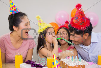 Cheerful family with cake and gifts at a birthday party