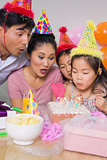 Family blowing cake at a birthday party