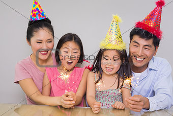 Cheerful family of four playing with firecrackers