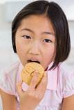Close-up portrait of a young girl eating cookie