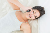 Close-up of a happy woman using mobile phone in bed