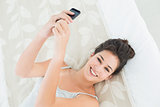 Portrait of relaxed woman with mobile phone in bed