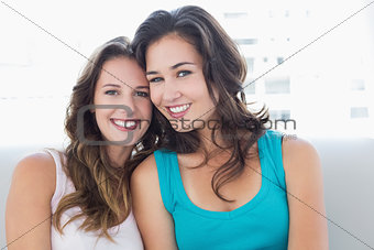 Two smiling female friends in the living room