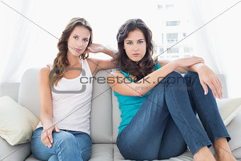 Relaxed young female friends sitting in living room