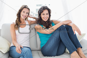 Happy relaxed female friends sitting in living room
