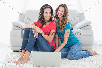 Female friends using laptop in the living room