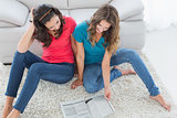 Female friends reading a book in the living room