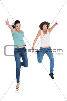 Two cheerful young female friends with hand gestures