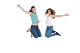 Two cheerful young female friends jumping