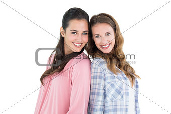 Happy young female friends standing back to back