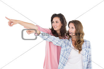 Friends pointing away against white background