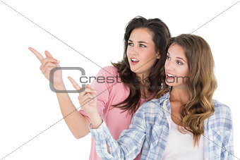 Friends pointing away against white background