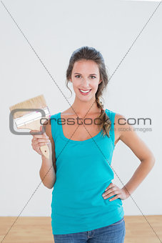 Woman holding paint brush in a new house