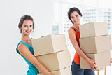 Female friends carrying boxes in in new house