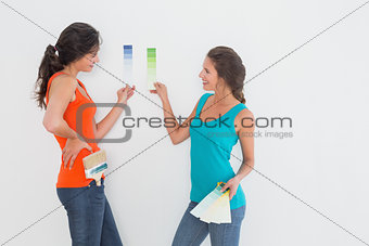 Side view of two female friends choosing color