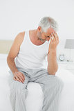 Mature man suffering from headache in bed