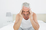 Man suffering from headache in bed