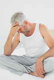 Mature man suffering from headache in bed