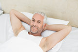 Portrait of a smiling mature man resting in bed